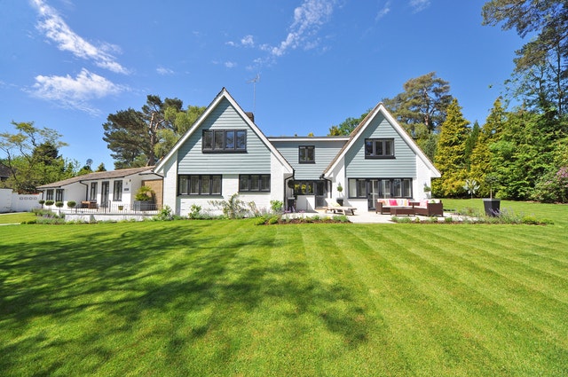 A large white house with a green lawn located outside of Dallas, Texas